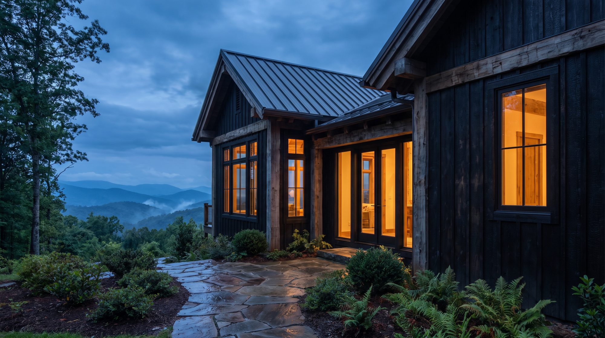 Study: a charred timber cabin exterior with standing seam roof and warm interior light, river stone paving at dusk